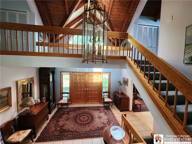 living room with beamed ceiling, tile floors, wood ceiling, and a notable chandelier