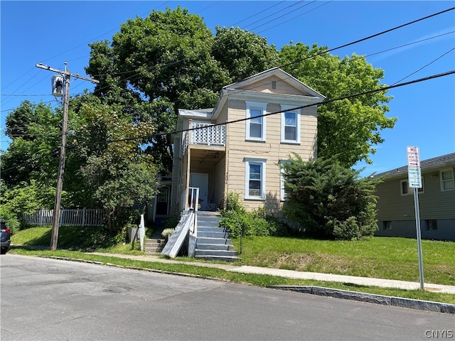 view of front of property featuring a balcony and a front yard