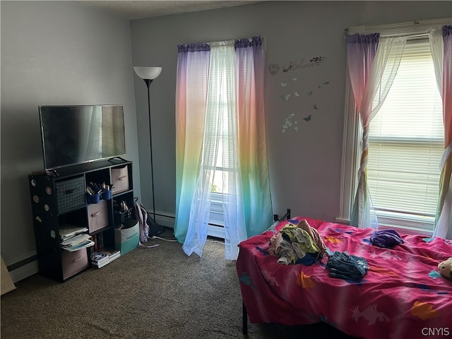 bedroom with carpet floors and a baseboard heating unit