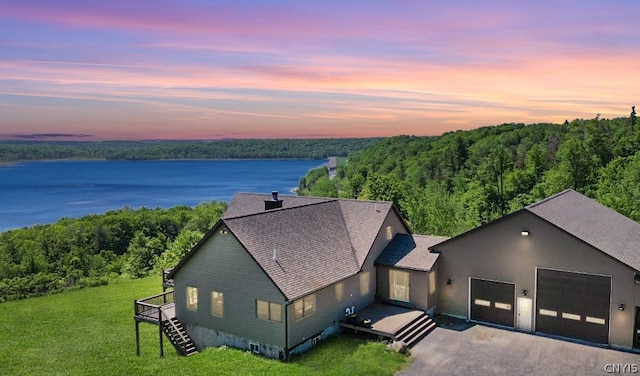 aerial view at dusk featuring a water view