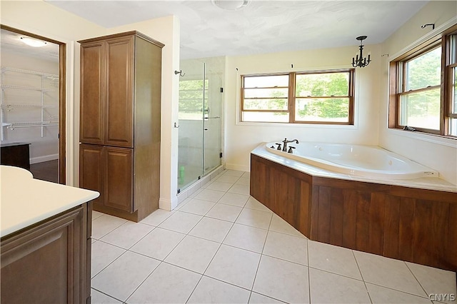 bathroom with tile patterned floors, a notable chandelier, separate shower and tub, and vanity