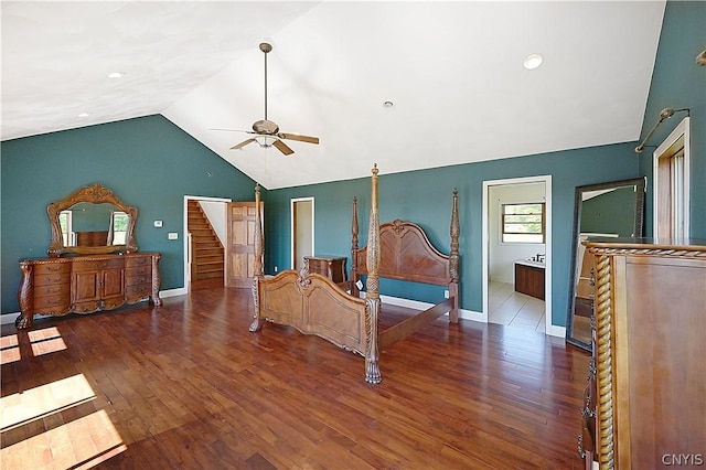 bedroom featuring dark hardwood / wood-style floors, ensuite bath, ceiling fan, and lofted ceiling