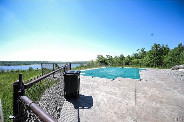 view of pool featuring a patio area and a water view