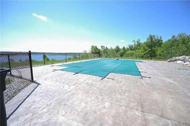 view of pool featuring a patio and a water view