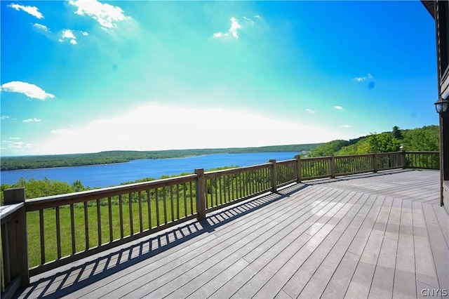 wooden terrace with a water view and a yard