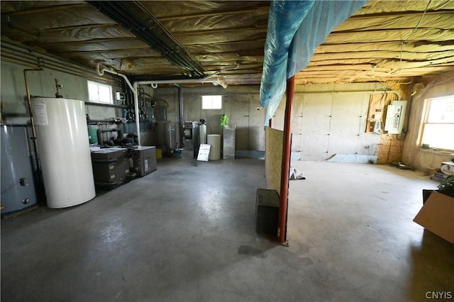 basement featuring electric panel and water heater