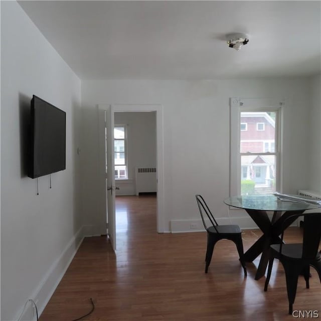 unfurnished dining area featuring dark hardwood / wood-style flooring and radiator