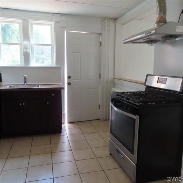 kitchen with extractor fan, light tile patterned flooring, stainless steel range with gas cooktop, and sink