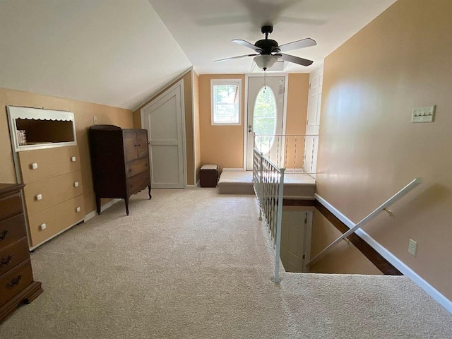 interior space with ceiling fan, light colored carpet, and lofted ceiling