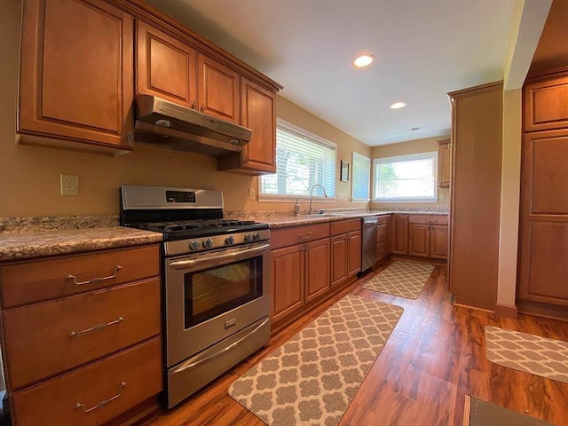 kitchen featuring light stone counters, wood-type flooring, and appliances with stainless steel finishes