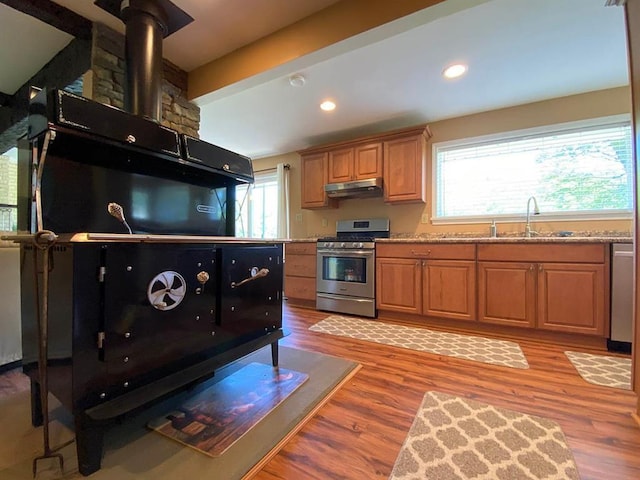 kitchen with light hardwood / wood-style flooring, beamed ceiling, stainless steel appliances, and sink