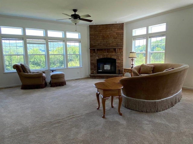 carpeted living room featuring a fireplace, plenty of natural light, ornamental molding, and ceiling fan