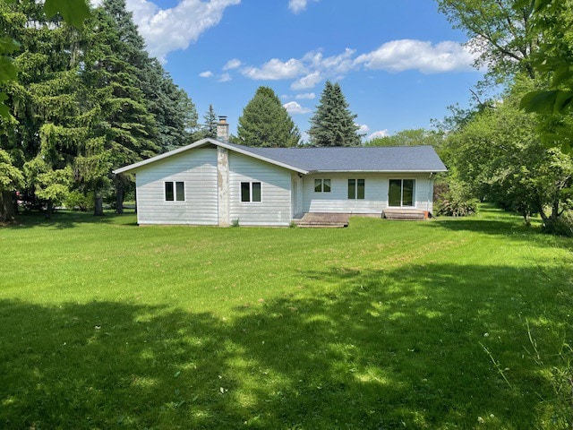 rear view of property featuring a lawn