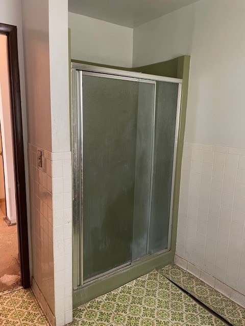 bathroom with an enclosed shower and tile flooring