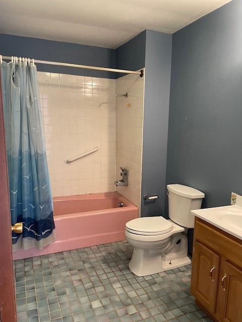 full bathroom featuring tile floors, vanity, toilet, and shower / bath combo with shower curtain