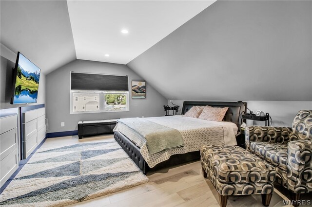 bedroom featuring light wood-type flooring and lofted ceiling