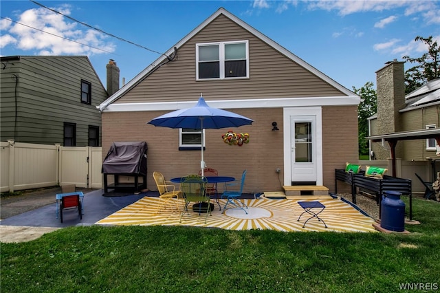 rear view of house featuring a patio and a lawn