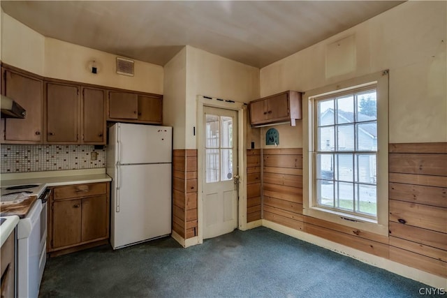 kitchen with visible vents, dark colored carpet, light countertops, freestanding refrigerator, and brown cabinetry