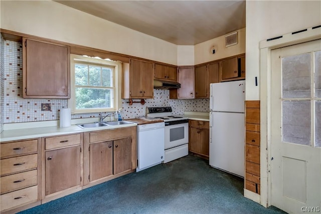 kitchen with a sink, light countertops, tasteful backsplash, and white appliances