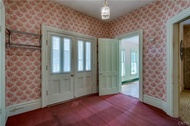 entryway featuring plenty of natural light, carpet, and wallpapered walls