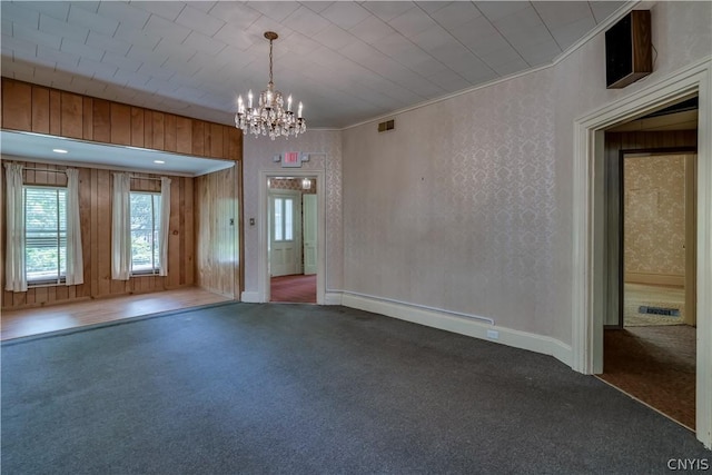 unfurnished room with visible vents, baseboards, an inviting chandelier, and carpet floors