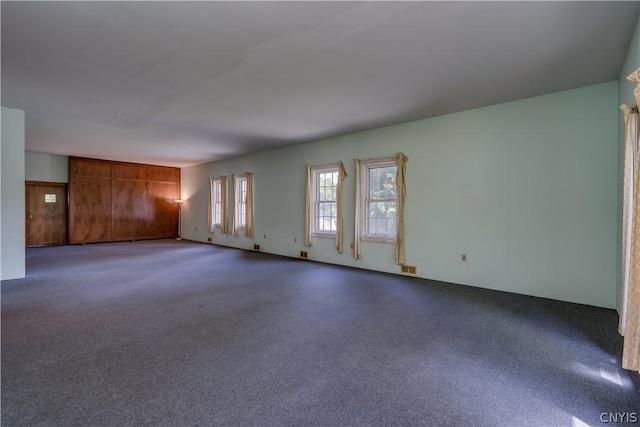 unfurnished living room with carpet flooring and visible vents
