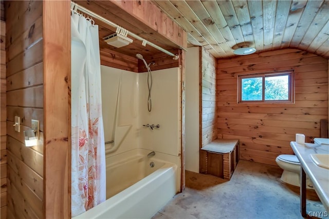 full bathroom featuring wooden walls, unfinished concrete floors, toilet, lofted ceiling, and shower / bath combo with shower curtain