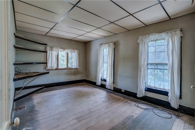 spare room featuring wood-type flooring and baseboards