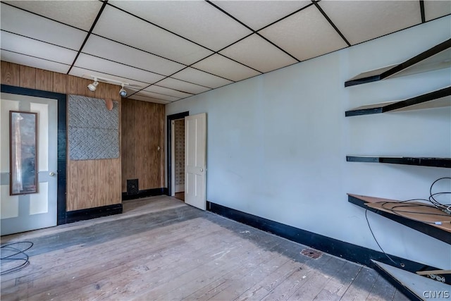 unfurnished room with baseboards and hardwood / wood-style flooring
