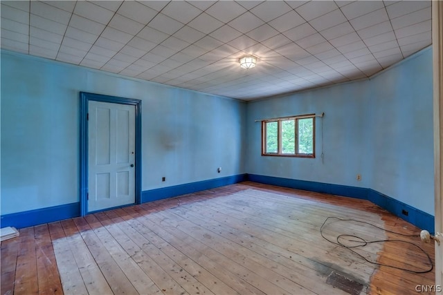 empty room featuring hardwood / wood-style flooring and baseboards