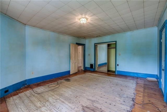 unfurnished room with wood finished floors and baseboards