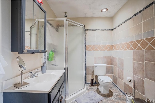 bathroom featuring an enclosed shower, vanity, toilet, and tile walls