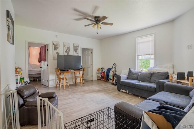 living room featuring light hardwood / wood-style flooring and ceiling fan