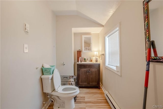 bathroom featuring vanity, toilet, wood-type flooring, and vaulted ceiling