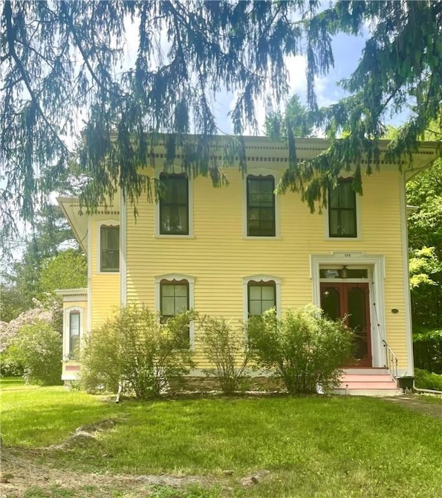 rear view of house featuring a lawn