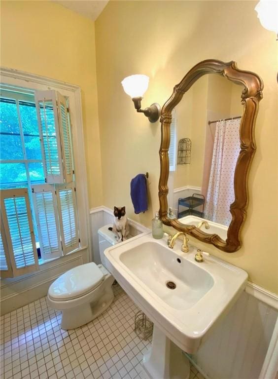 full bath with toilet and tile patterned floors