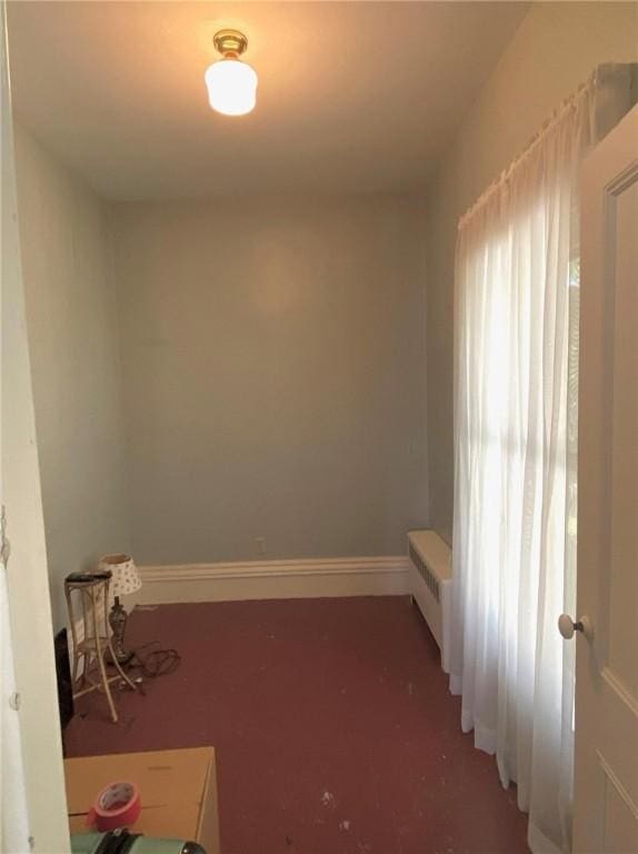 interior space with radiator heating unit, carpet flooring, and baseboards