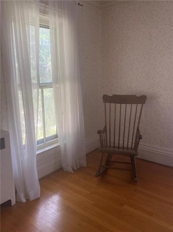 unfurnished room with light wood-type flooring, baseboards, and wallpapered walls