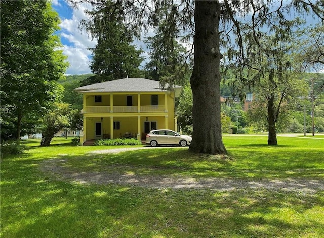 view of front of home with a front yard and a balcony