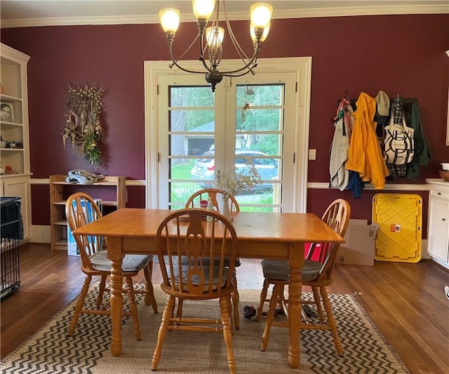 dining space featuring ornamental molding, dark wood-type flooring, and an inviting chandelier