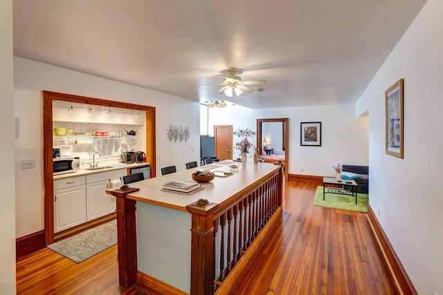 interior space with hardwood / wood-style flooring, ceiling fan, and sink