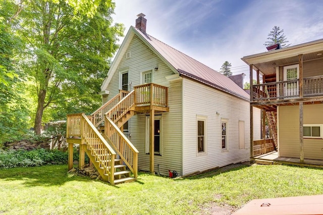 back of house featuring a wooden deck and a yard