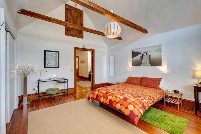 bedroom with beam ceiling, wood-type flooring, high vaulted ceiling, and a closet