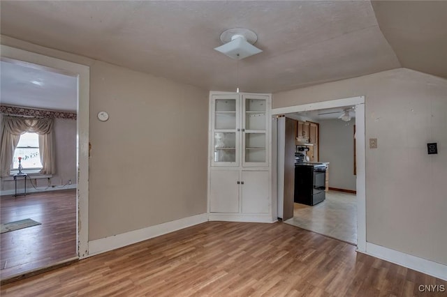 empty room with hardwood / wood-style flooring and lofted ceiling