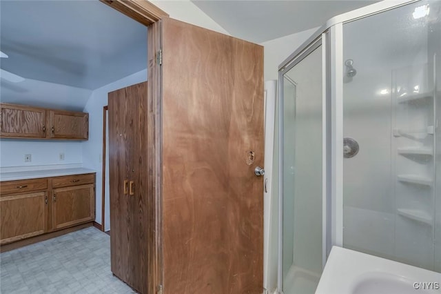 bathroom with lofted ceiling and a shower with shower door