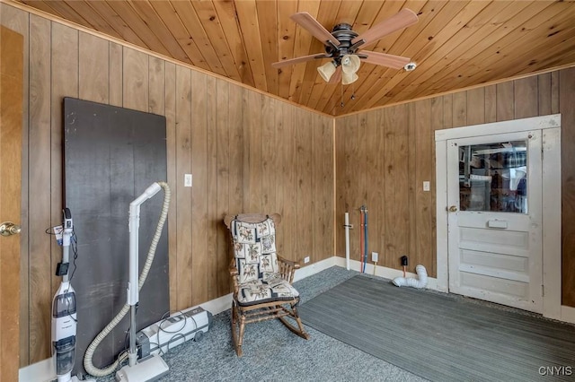 unfurnished room with dark carpet, wooden walls, wooden ceiling, and ceiling fan