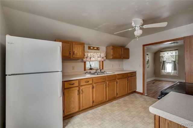 kitchen featuring lofted ceiling, sink, white fridge, range with electric cooktop, and ceiling fan