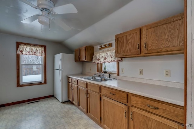 kitchen with sink, vaulted ceiling, ceiling fan, and white fridge