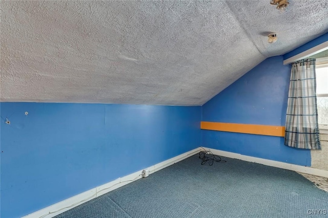 additional living space featuring carpet flooring, vaulted ceiling, and a textured ceiling