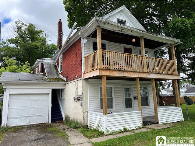 view of front of home featuring a porch, a garage, and a balcony